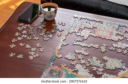 Cup of coffee, mobile phone and jigsaw puzzle pieces together. Stay at home concept. Home quarantine.  - Powered by Shutterstock