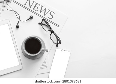 Cup of coffee, newspaper, tablet computer and mobile phone on white background