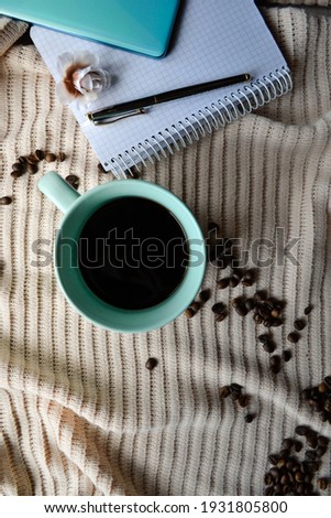 cup of coffee next to notebook with mobile phone and pen on it