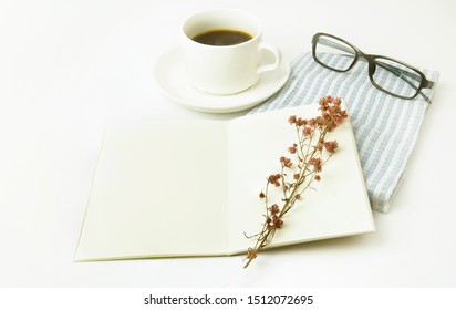 cup of coffee and notebook on table.