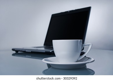 Cup of coffee and notebook in soft-focus