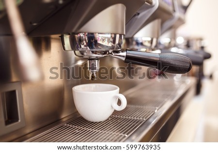 A cup of coffee is on the espresso machine