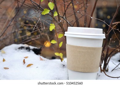 Cup Of Coffee On The Snow Under A Bush