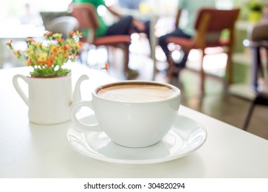 Cup of coffee on a table with flowers - Shutterstock ID 304820294