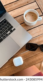 Cup of coffee on a table with notebook and sunglasses for work from home