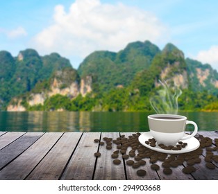 Cup With Coffee On Table Over Lake