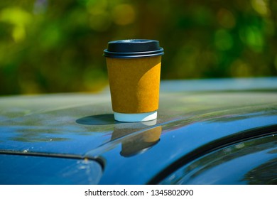 A Cup Of Coffee On Top Of Car Roof.