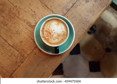 Cup Of Coffee On Wooden Table In Cafe. Top View

