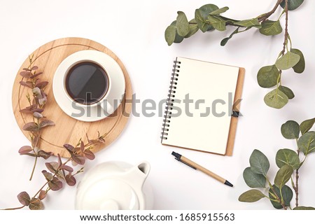 Cup coffee, pencil, branch with leaf, paper note on white