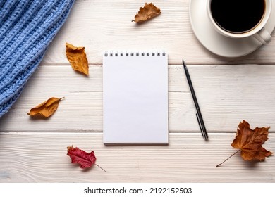 Cup of coffee, plaid, notepad, autumn leaves on white wooden background. - Powered by Shutterstock