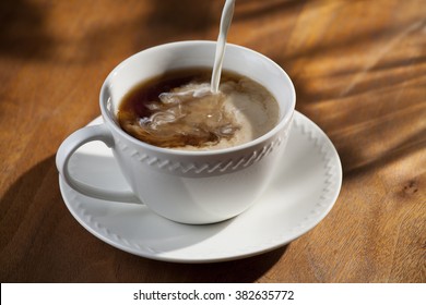 Cup Of Coffee With Pouring Creamer