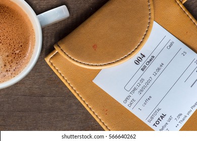cup of coffee and receipt bill in folder payment on wooden table - Powered by Shutterstock