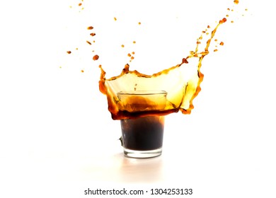 A cup of coffee with splashes in the process of spilling on a white background