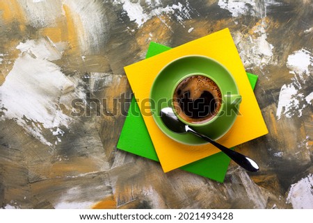 Cup of coffee and spoon at colorful abstract background texture. Coffee break time concept