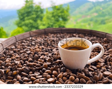 Cup of coffee standing in the middle of coffee beans, natural background