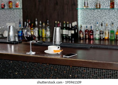 Cup Of Coffee Standing On A Bar Counter Alongside A Half Empty Glass Of Red Wine After A Customer Has Tried To Sober Up Before Leaving For Home