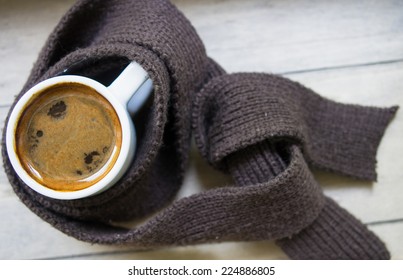 Cup of coffee surrounded the warm scarf