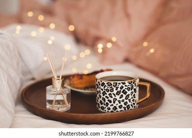 Cup Of Coffee In Tray With Home Fragrance In Glass Bottle With Sticks And Tasty Cake In Bed Close Up. Good Morning. Breakfast Time. Aromatherapy. Home Cozy Atmosphere. 