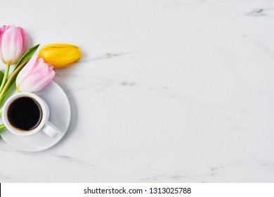 Cup Of Coffee With Tulips On White Marble Table. Spring Flowers. Top View. Copy Space For Text. Spring Concept.