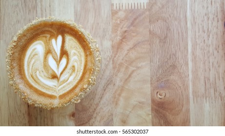 Cup Of Coffee With Two Hearts Milk Foam Pattern And Peanut Butter Crumble Coated Cup Mouth On Wooden Background.