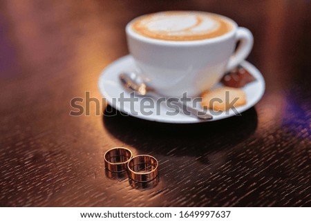 Cup of coffee and wedding rings
