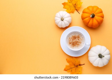 Cup Of Coffee And White And Orange Pumpkins On The Orange Background, Autumn Flatlay Concept