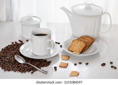a cup of coffee, wholegrain cookies on a saucer, on a table by the window, light comes through the curtain and illuminates the table, roasted coffee beans , photographed inside the house - Shutterstock ID 2151084597