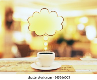 Cup Of Coffee With Yellow Speach Bubble On Wooden Table