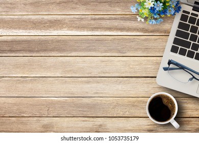 Cup of coffee,laptop computer,glasses and fresh flower on a office desk or wood table background. Top view with copy space. Wooden background for any design and use.