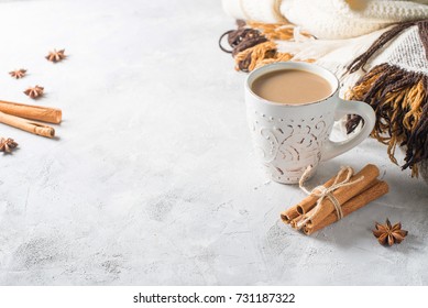 Cup Of Creamy Latte With Spices And Cozy Plaids Over Grey Texture. Selective Focus