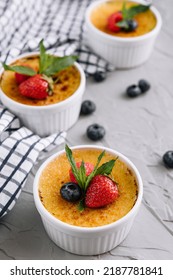 Cup Of Creme Brulee With Dessert Plug And Mint Leave With Berries