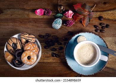 A cup of espresso and a bowl of cookies.