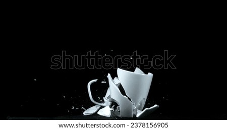 Cup falling and exploding on Black Background