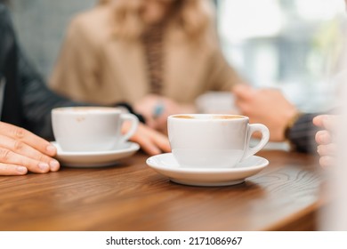 A cup of filter coffee on a table in a coffee shop, a noisy group of friends - Powered by Shutterstock