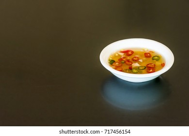 A Cup Of Fish Sauce On Black Desk