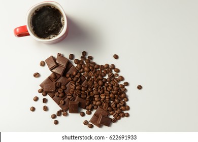cup of fragrant coffee, beans coffee and chocolate on white background. Top view.