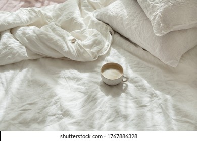 Cup Of Fresh Coffee In Bed, Morning Mood. Linen Cotton Textile Bedclothes. Organic And Natural Linen. Cozy Bedroom Interior. Beautiful Light.