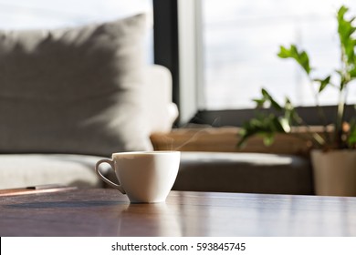 Cup Of Fresh Coffee Standing On The Table Against Window