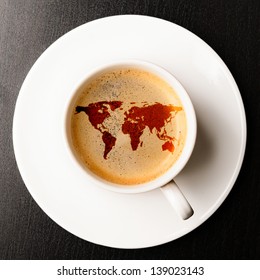cup of fresh espresso on table, view from above. Earth silhouette is from visibleearth.nasa.gov