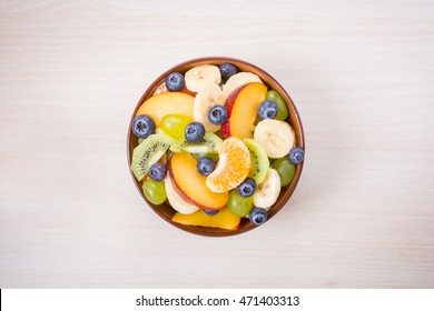 Cup Of Fresh Fruit Salad On A Wooden Background. Top View.