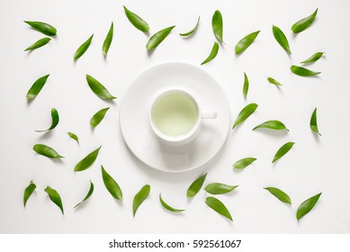 Cup Of Fresh Green Tea With Green Leaves Around It, View From Above