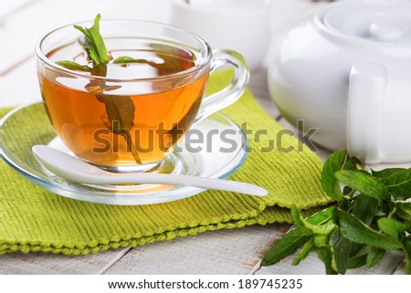 Cup of fresh herbal tea on wooden table. Selective focus, horizontal.