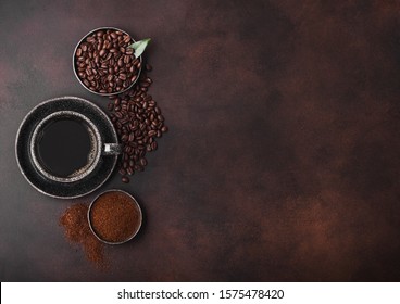 Cup Of Fresh Raw Organic Coffee With Beans And Ground Powder With Cane Sugar Cubes With Coffee Tree Leaf On Dark Background.