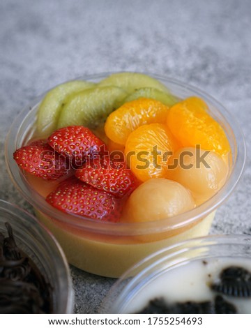 A cup of Fruit Pudding, contain some fruits as the topping. Such as Strawberry, orange, longan and Kiwi. The Pudding base is ButterPudding  