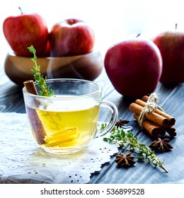 A cup of ginger tea with cinnamon and thyme. Hot Steam. Apples. Winter Autumn Christmas New Year Time. Selective focus.
