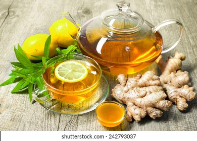 Cup of ginger tea with honey and lemon on wooden table