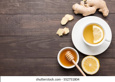 Cup of ginger tea with lemon and honey on wooden background. Copyspace for your text.