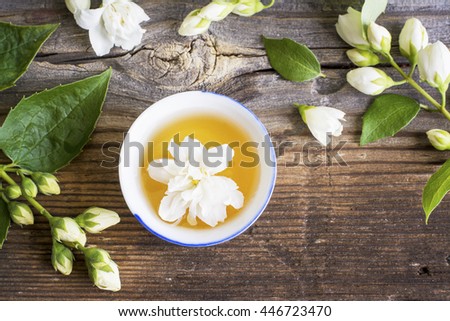 A cup of green tea infused with jasmine on a gray wooden background. selective focus