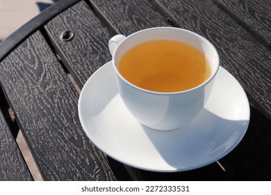 A Cup of green tea on black wooden background. Cleansing or detox tea is a good option for weight loss. Antioxidant properties. Copy space