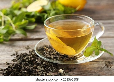 Cup with green tea on grey wooden background